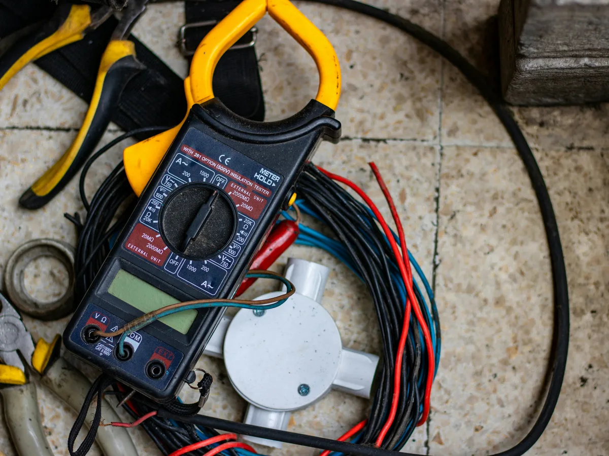 A clamp meter and wiring detail on a rewire