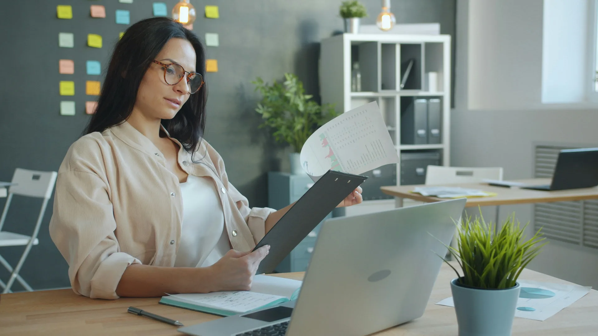 A desk team member reviewing a printed workflow sheet