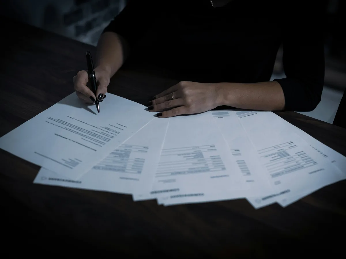 Hands working through bookkeeping paperwork in the evening